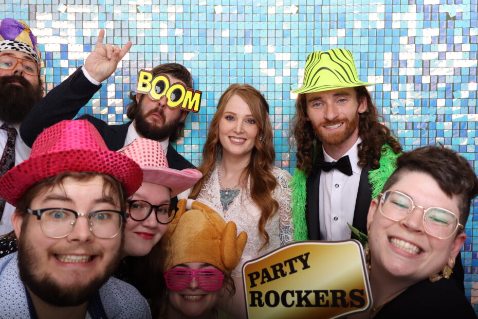 Wedding guests laughing and posing with props at open air photo booth rental in Winston-Salem NC by Shutter Down Sound and Media